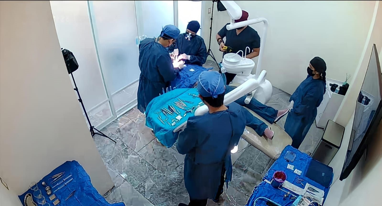 Equipo quirúrgico completo durante una cirugía de implantes dentales en el consultorio